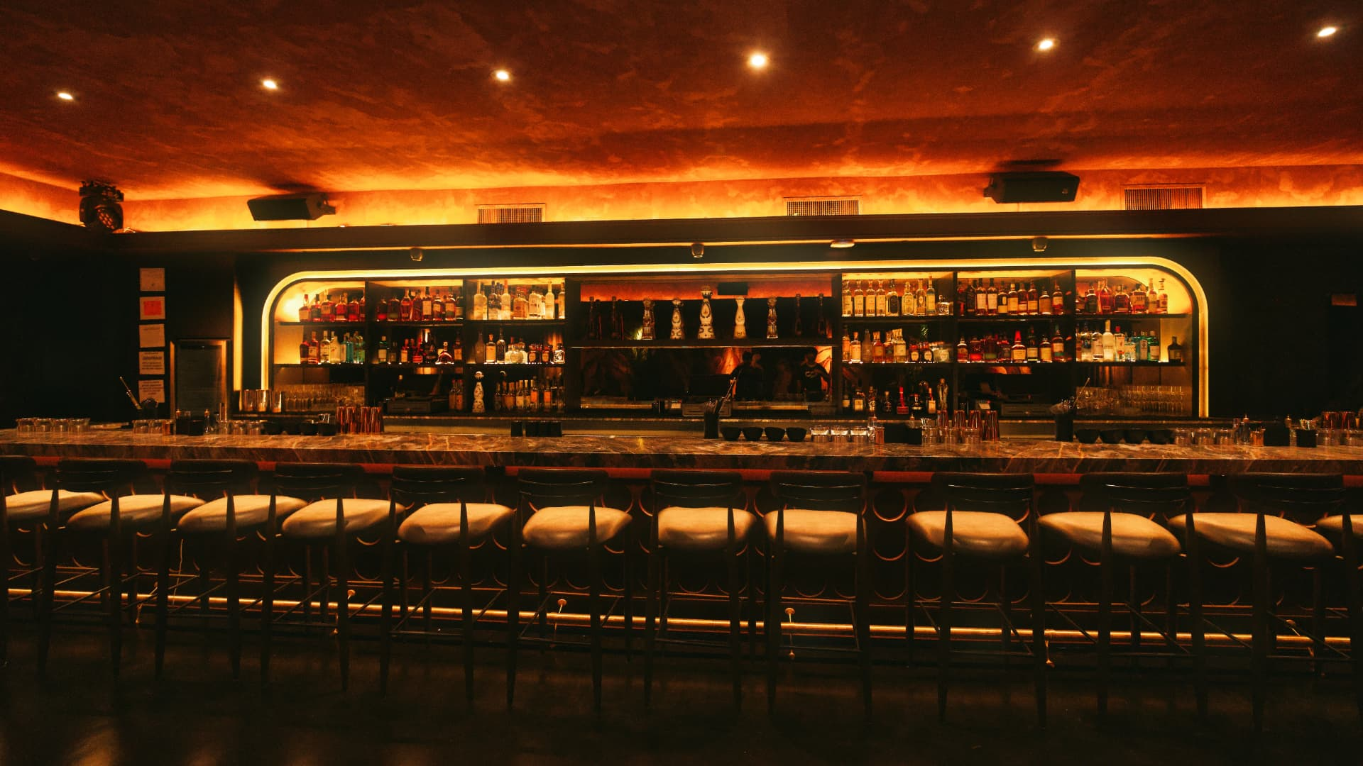 Arched backbar lined with bottles in golden light